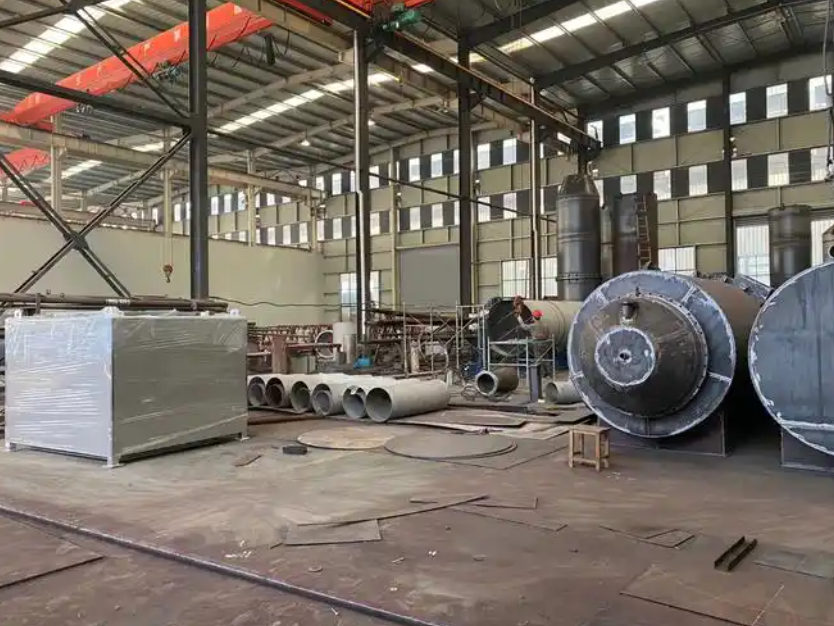 现代化的环保设备生产车间，工人们正在装配大型一体化污水处理罐体